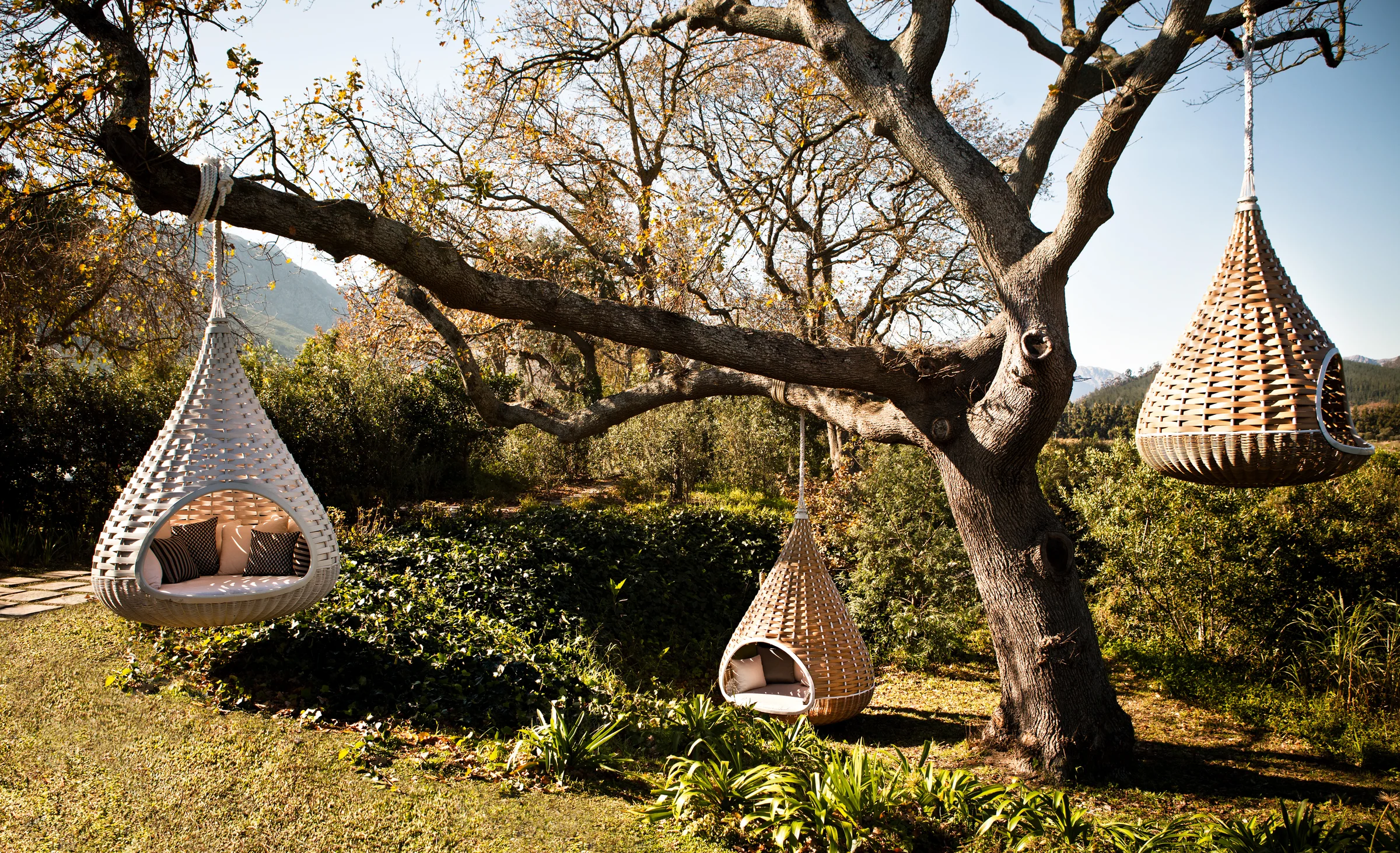 Dedon Nestrest hanging loungers in a garden